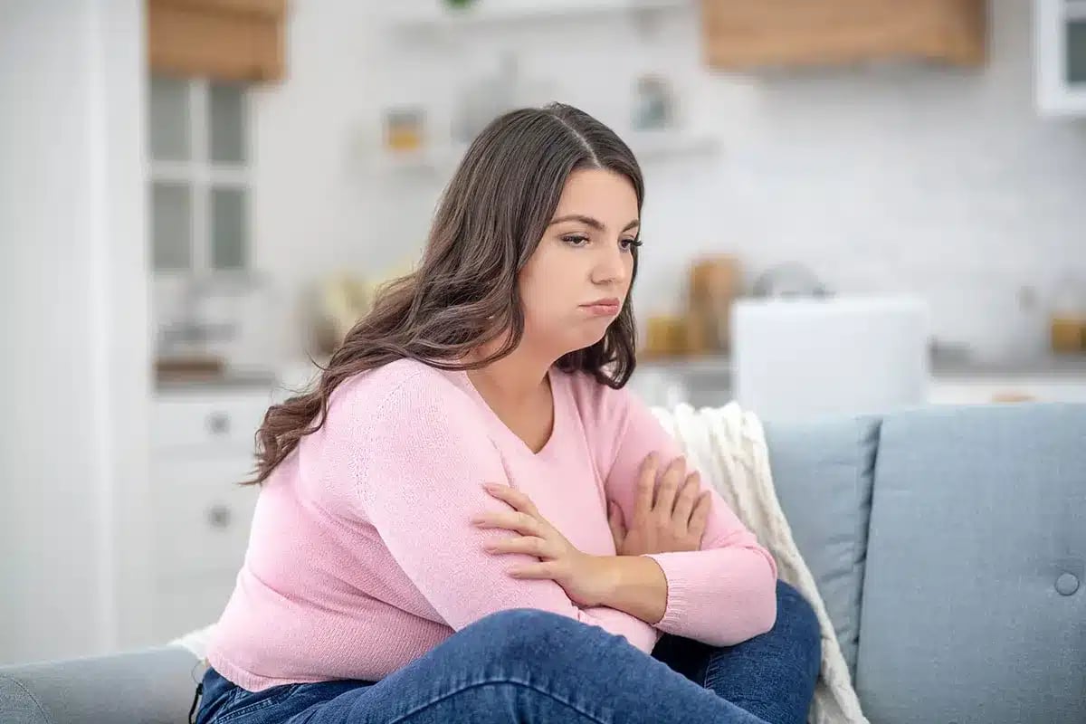 Thoughtful woman sitting on a couch.