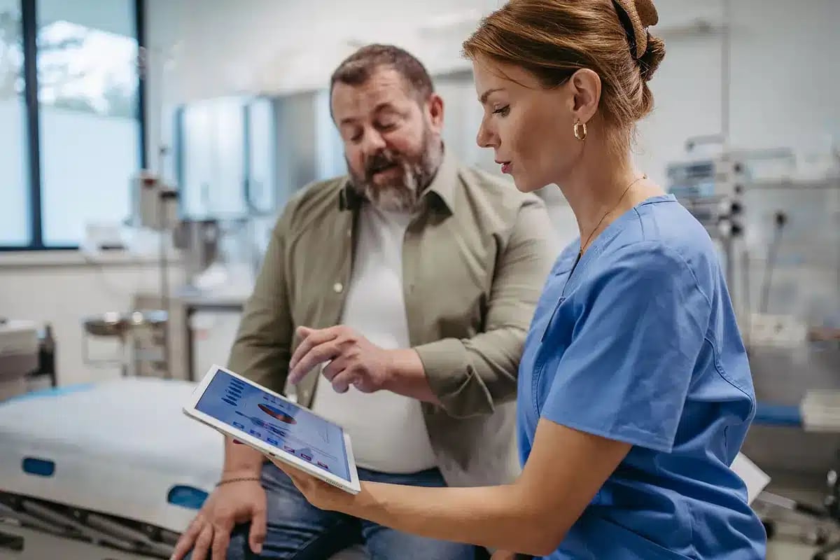 Doctor showing patient medical data on tablet.