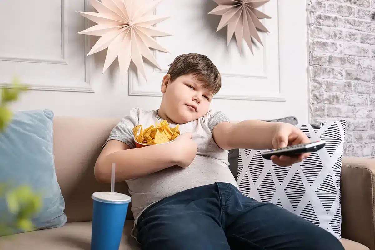 Overweight boy watching TV.