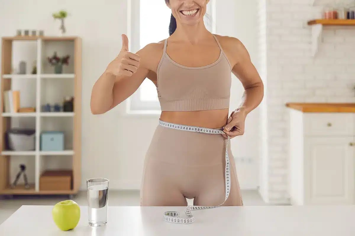 Woman measuring waist.