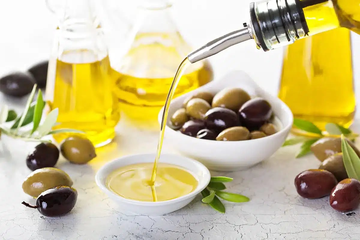 Olive oil being poured into a small bowl.