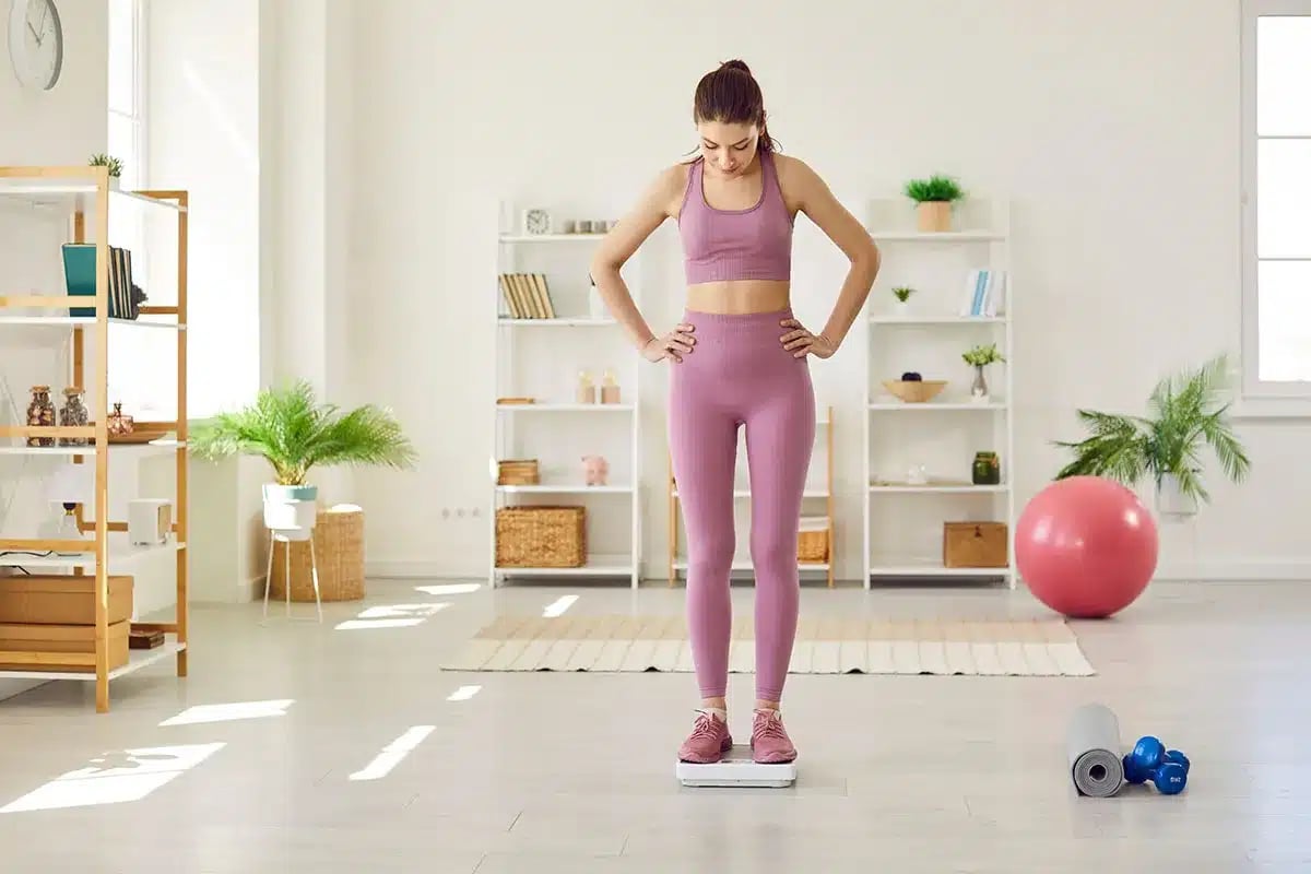Woman weighing herself.