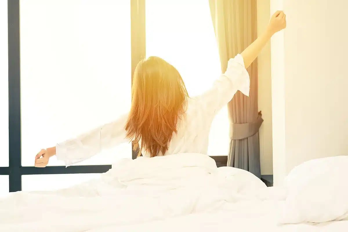Woman stretching in bed.