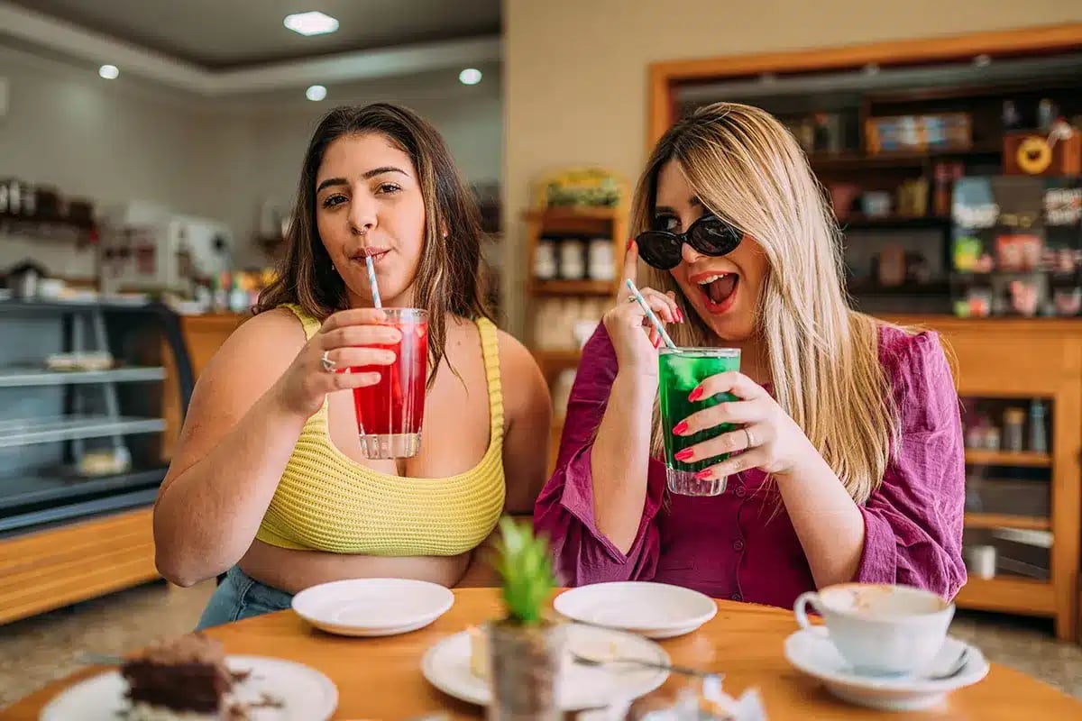 Two friends enjoying drinks at a cafe.