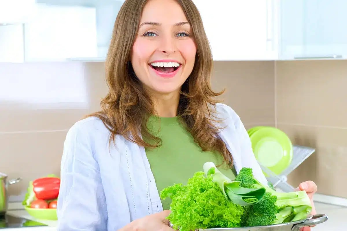 Happy woman holding fresh vegetables.