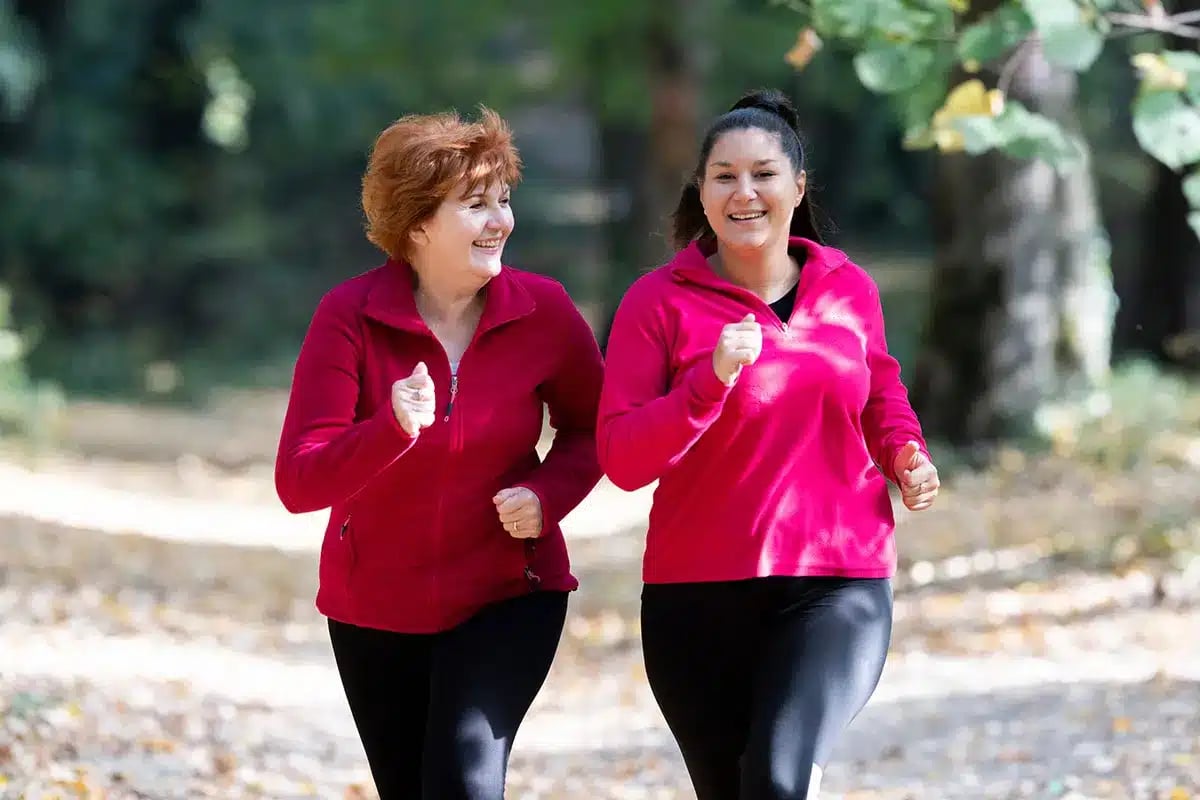 Two women jogging together outdoors.