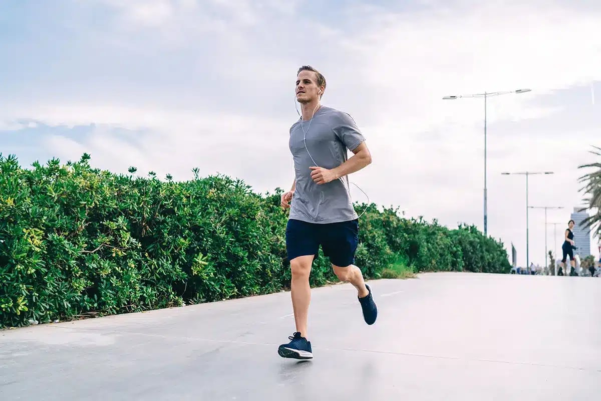 Man jogging outdoors, listening to music.