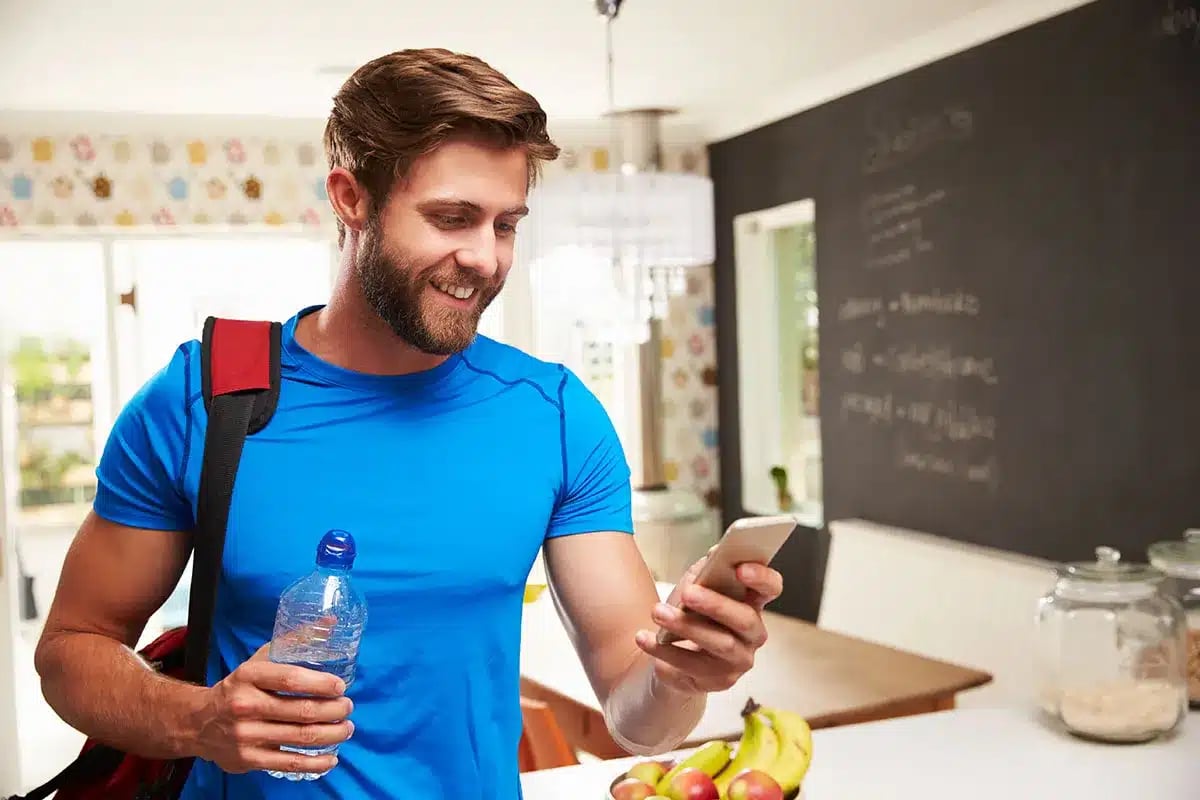 Man checking phone before workout.