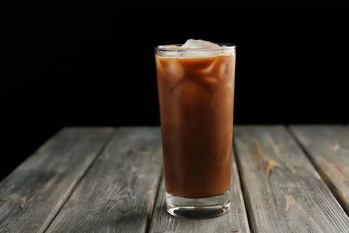 Glass of iced coffee on wooden table.