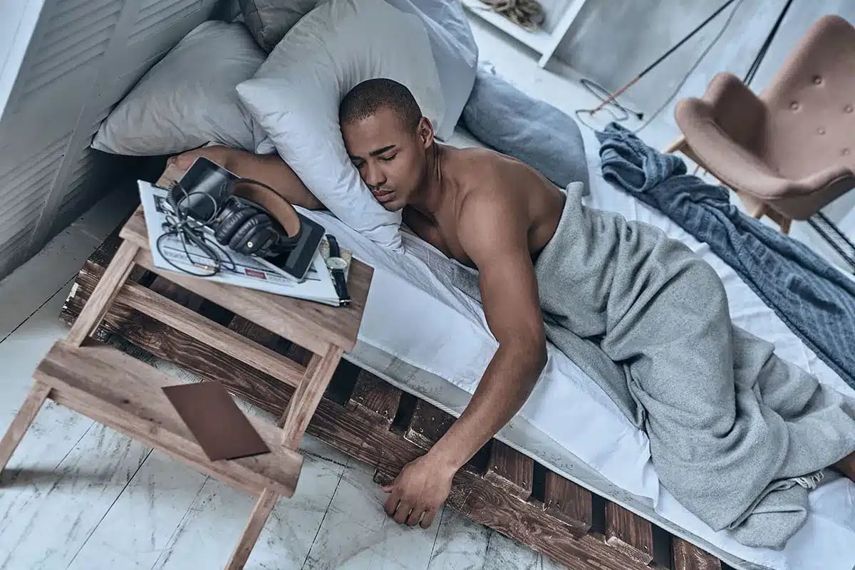 Man sleeping on a pallet bed.