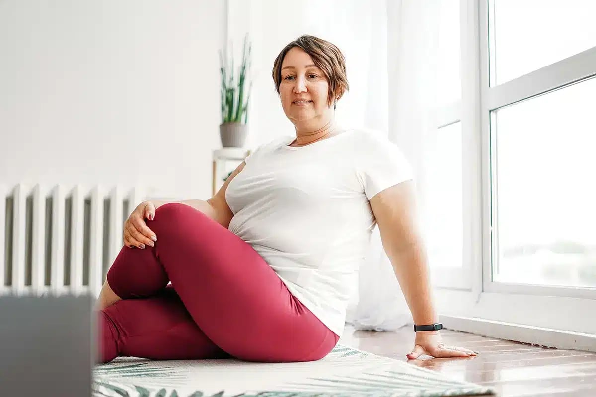 Plus-size woman doing yoga at home.