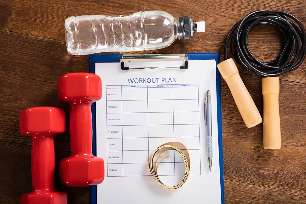 Fitness plan, dumbbells, jump rope, water bottle.