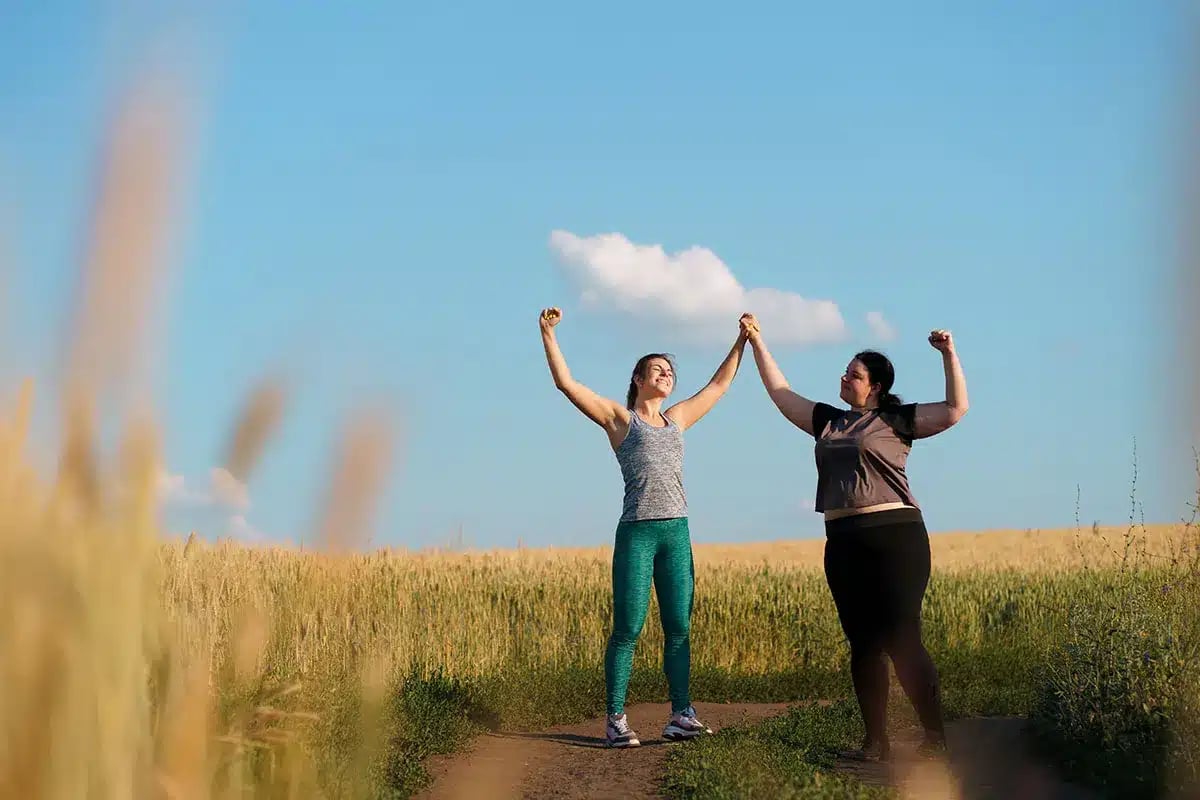 Two women celebrating fitness achievement.