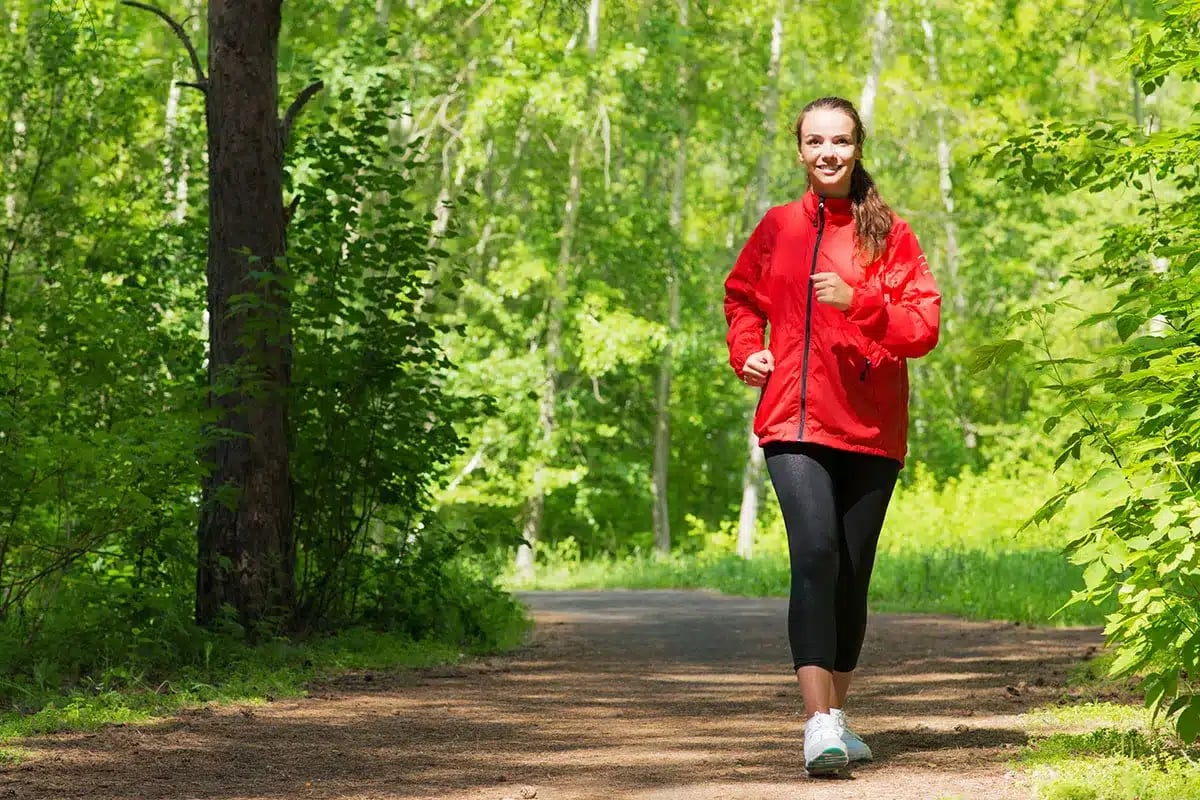 Woman jogging in a forest.