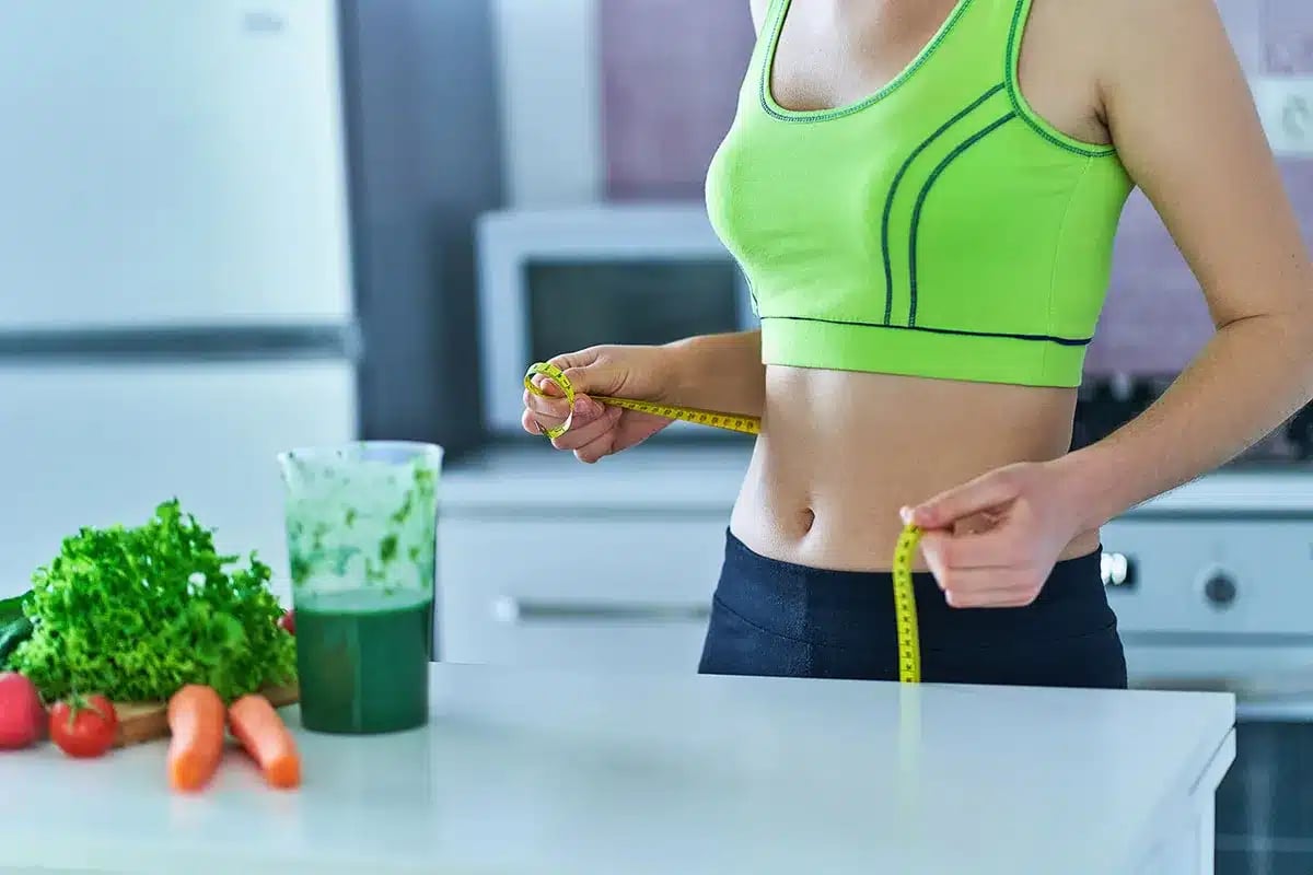 Woman measuring her waist.
