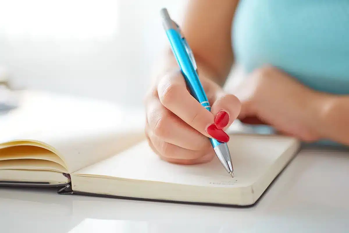 Woman writing in a notebook.