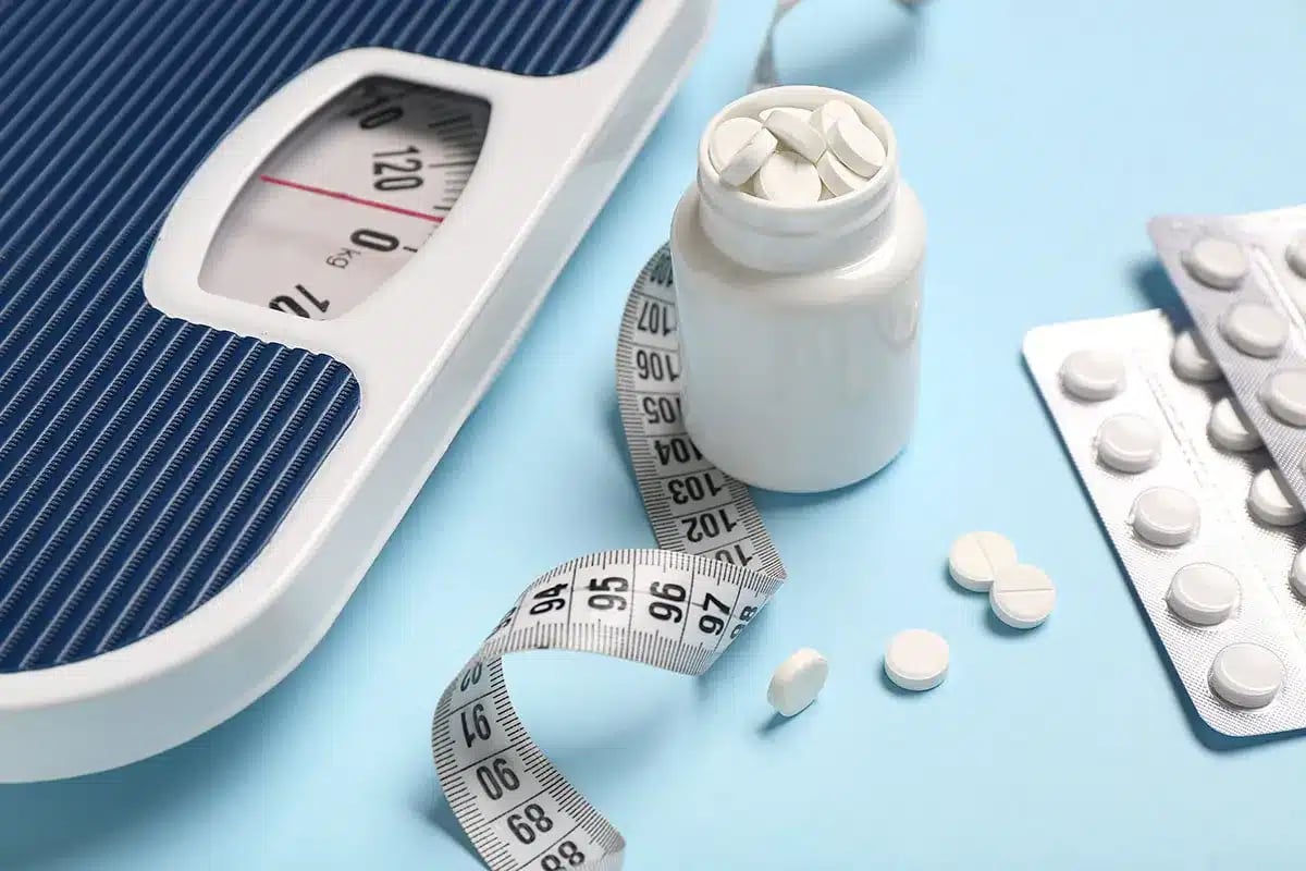 Weight scale, pills, and measuring tape.