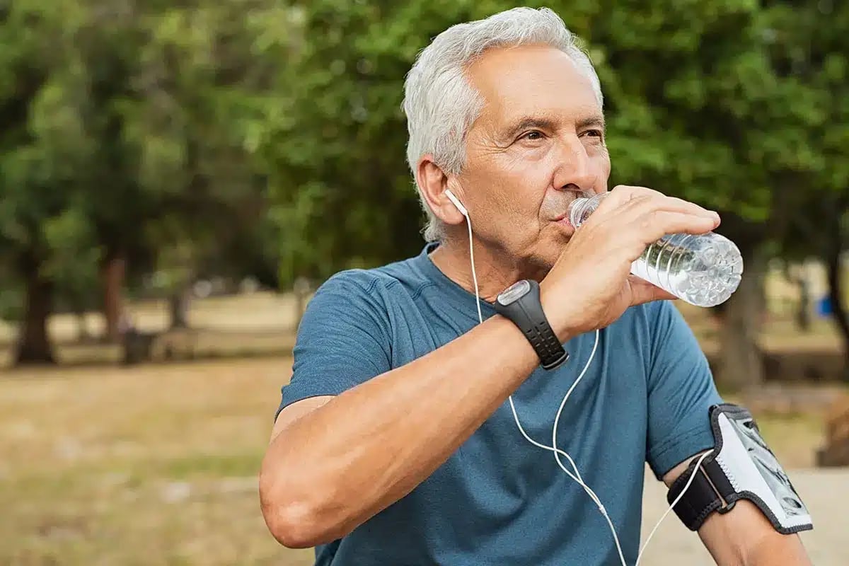 Senior man drinking water after exercise.