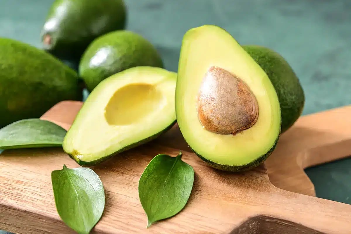 Ripe avocados on a wooden board.
