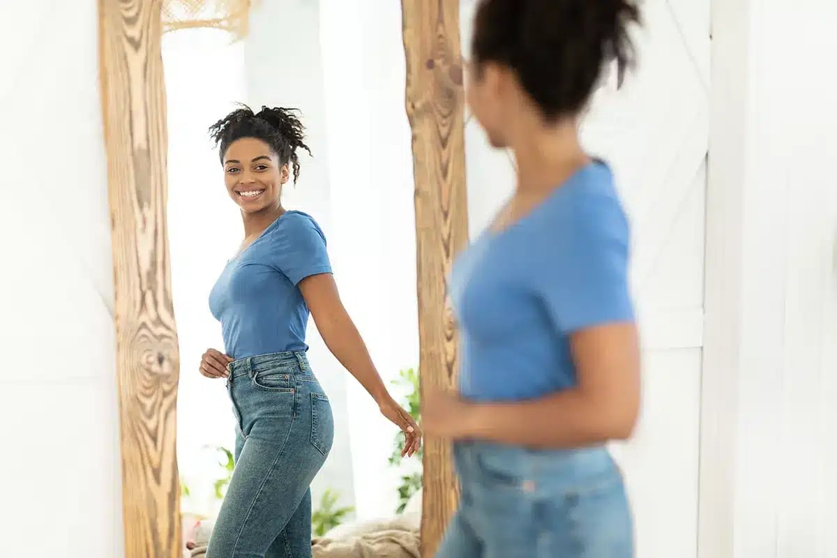 Happy woman looking in the mirror.