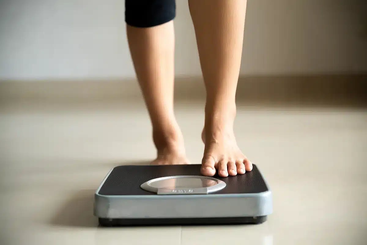 female leg stepping on weigh scales