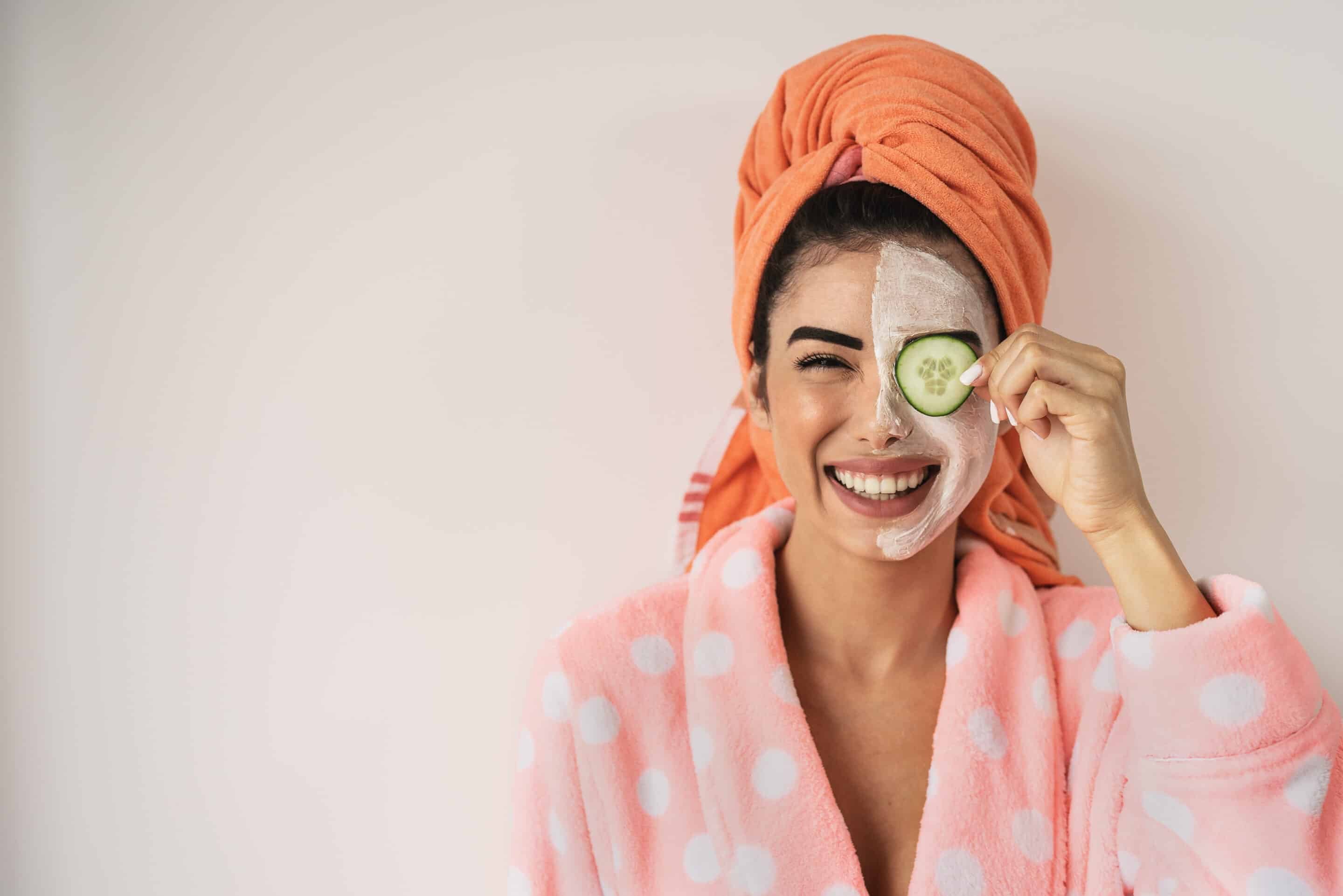 Happy smiling girl applying facial organic cream Healthy beaut